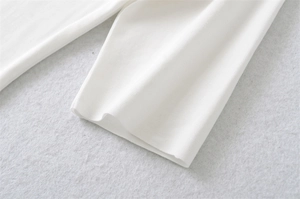 Close-up of white ribbed knit fabric texture on the sleeve cuff of a square neck T-shirt