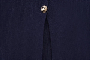 Gros plan détaillé sur un tissu en maille bleu marine avec un bouton rond en métal doré