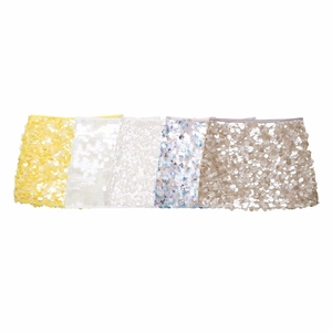 Détail montrant cinq mini-jupes à paillettes en jaune, blanc, bleu, argent et champagne
