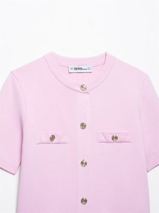 Detail der rosa Strickjacke mit strukturierter Textur und goldenen Knöpfen
