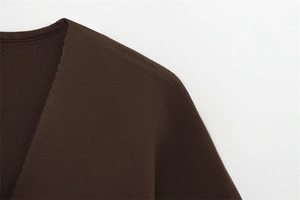 Détail macro du haut en tricot marron foncé avec col en V et texture de tricotage fine