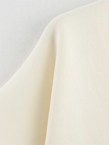 Vue macro détaillée de la texture du tissu en maille blanc cassé et de sa matière douce