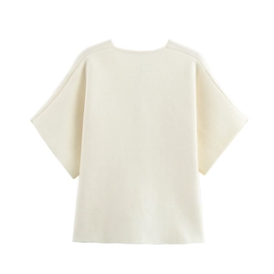 Détail montrant la texture lisse et le tricot plat de ce haut beige à manches courtes