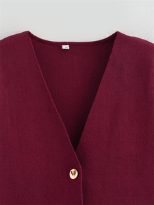 Détail du cardigan en tricot bordeaux avec col en V et bouton doré poli brillant