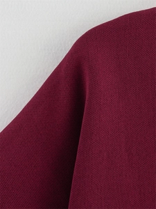Détail rapproché du haut en tricot bordeaux montrant la texture des mailles plates