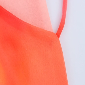 Detailansicht aus leichtem orange-rosa Chiffonstoff mit dünnem Schulterriemen