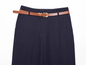 Dettaglio dei pantaloni a vita alta blu navy con cintura in pelle marrone e fibbia oro