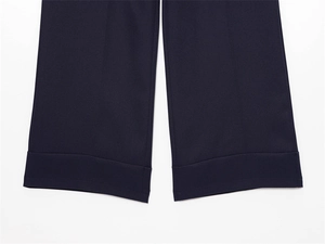 Dettaglio dell'orlo risvoltato blu scuro su pantaloni a gamba larga con cuciture