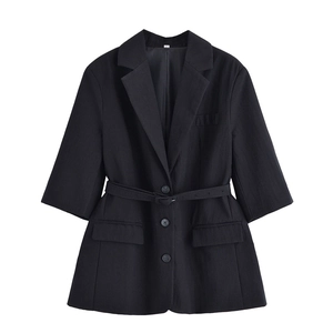 Close-up of black blazer with fabric belt, three buttons and large flap pockets