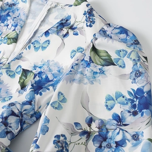 Detalle de vestido de lino con cuello en V y estampado floral azul con mangas abullonadas
