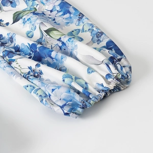Detailed view of elastic cuffs and floral butterfly print on puff sleeve dress