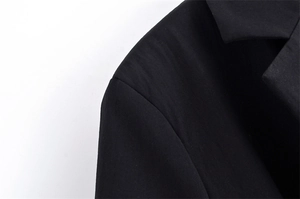 Close-up of the professional stitching and smooth fabric texture on black blazer shoulders