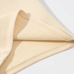 Detail of high-quality double-needle stitching and overlock edge on beige knit top