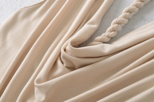 Detailaufnahme der geflochtenen Träger und der beigen Stricktextur des rückenfreien Tops
