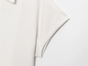 Detail view of the stitching and fabric texture on a white short-sleeve shirt