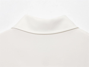 Close-up of white short-sleeved top collar featuring neat stitching and smooth fabric