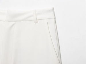 Detailed macro view of white trousers showing waist belt loops and side pocket seams