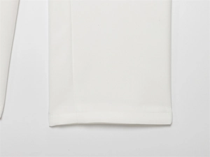 Detailed close-up showing the hem stitching and white suit fabric texture of the garment