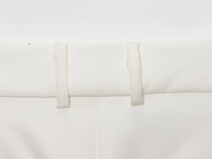 Detail of white trousers showing reinforced belt loops and high-density plain weave fabric