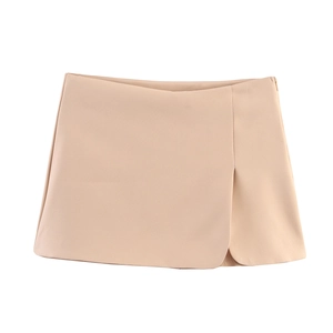 Detail of beige skort showing front slit design, layered fabric, and side zipper closure