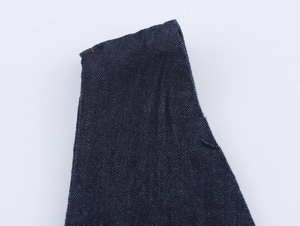 Gros plan détaillé du tissu denim bleu foncé avec texture sergée et coutures apparentes