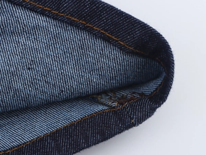 Gros plan détaillé du denim bleu foncé avec des coutures contrastées orange renforcées