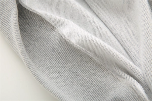 Detailaufnahme von hellgrauem French Terry Stoff mit Rippbündchen und sauberen Nähten