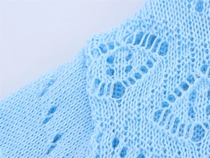 Détail de maille ajourée bleu clair avec texture et motifs au crochet complexes