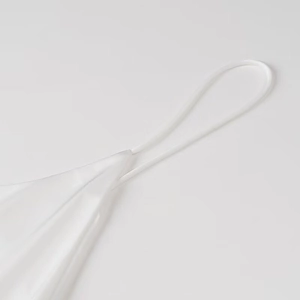 Close-up of white satin dress detailing thin spaghetti straps and silky fabric texture