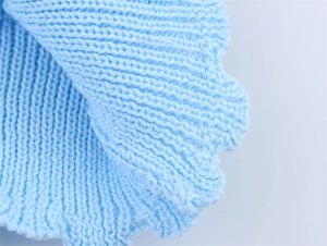 Détail de la maille bleu ciel montrant la texture et le bord ondulé à volants