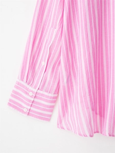 Detailed macro view of pink striped cotton shirt sleeve showing white resin button and neat stitching