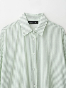 Detail of the light green striped shirt collar and buttons on soft cotton fabric