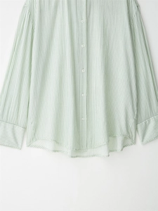 Close-up of light green striped long sleeve shirt with white buttons and fabric texture