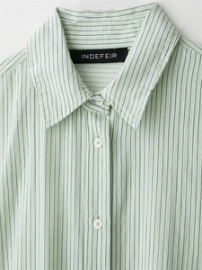 Close-up of the light green striped shirt collar with brand label and white buttons