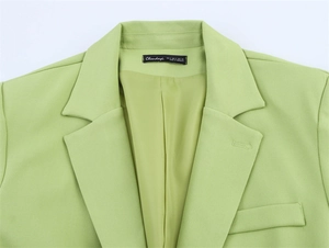 Detail eines hellgrünen Blazers mit Reverskragen und glattem Innenfutter mit Markenetikett