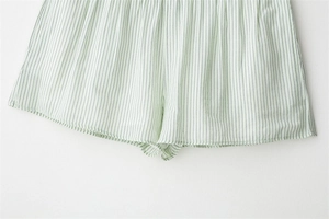 Detail of green pinstripe casual shorts featuring clean hem stitching and cotton fabric