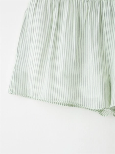 Close-up of thin vertical black stripes on light green breathable lounge shorts fabric