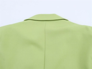 Detaillierte Nahaufnahme der hinteren Ausschnitt- und Schulternähte eines salbeigrünen Blazers
