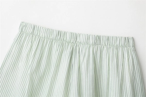 Detail view of elastic waistband on light green and white striped cotton shorts