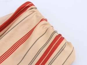 Close-up of elastic knitted fabric with red and grey stripes and drawstring pleats