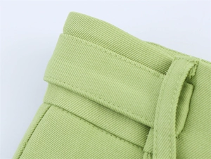 Detailansicht aus hellgrünem Twill-Stoff mit präzisen Doppelnähten und Gürtelschlaufen