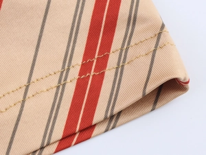 Detail of red and grey stripes on beige knit fabric with double-needle stitching