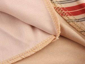 Macro view of beige striped fabric showing detailed overlock stitching and knit texture