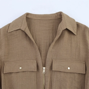 Details des khakifarbenen Safari-Hemdes mit Reißverschluss und Cargo-Taschen mit Metallknöpfen