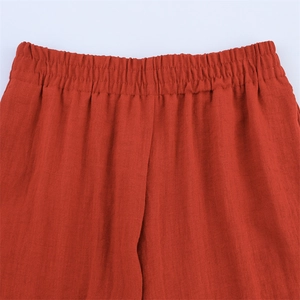Detailansicht des elastischen Bundes der orangefarbenen Leinenhose mit weitem Bein