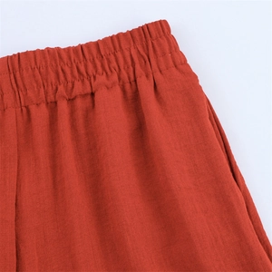 Detail der orangefarbenen Hose mit elastischem Bund und strukturierter Baumwoll-Leinen-Optik