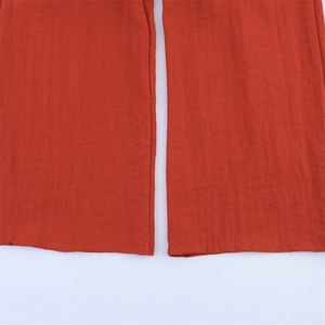 Detailaufnahme der rostroten weiten Hose mit hochwertiger Baumwoll-Leinen-Textur