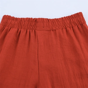 Makro-Detail des elastischen Bunds und Leinentextur der rostorangefarbenen weiten Hose