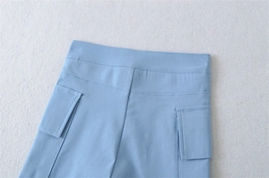 Detailed view of the waistline and symmetrical patch pockets on light blue utility shorts
