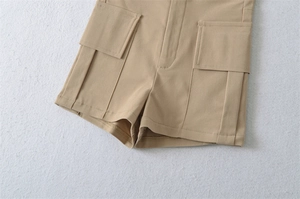 Detail of khaki cargo shorts showing twill cotton fabric and large utility pockets
